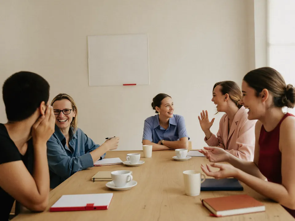 A small team laughing together around a table